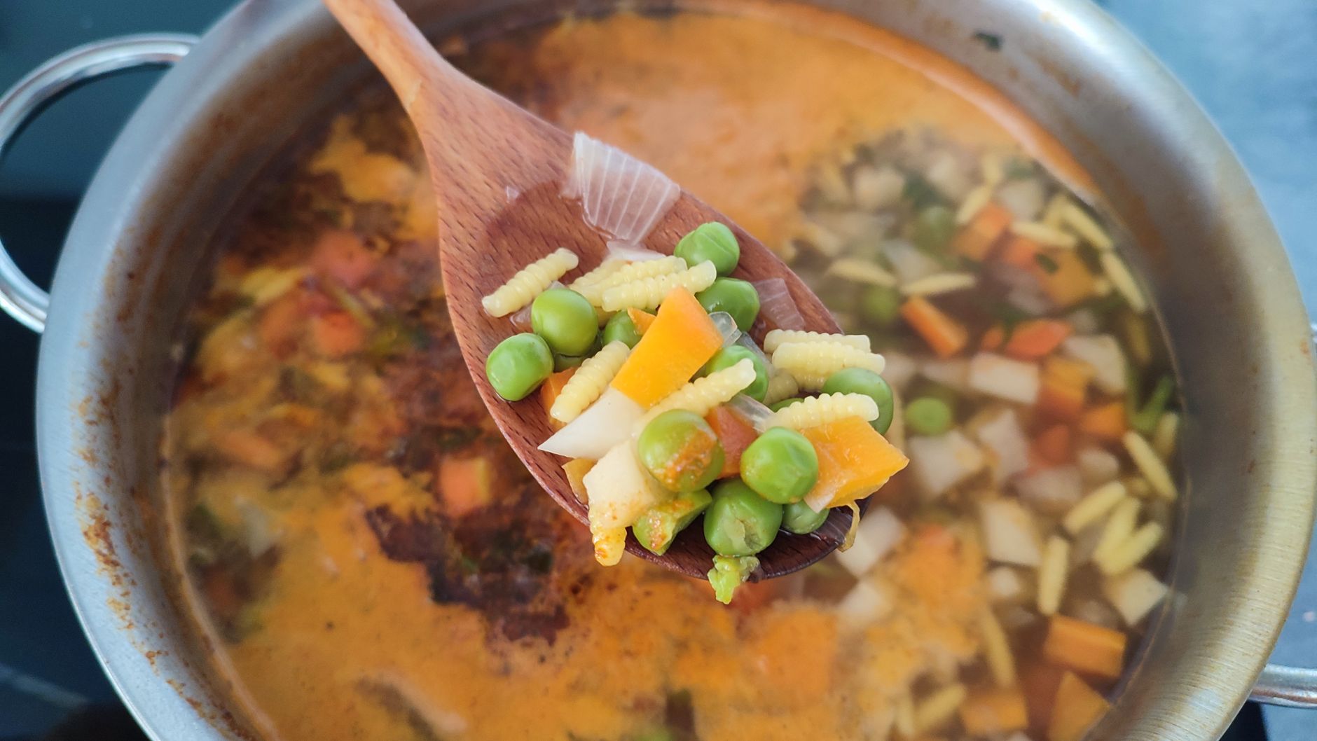 鍋で煮ている野菜を木べらですくったところ
